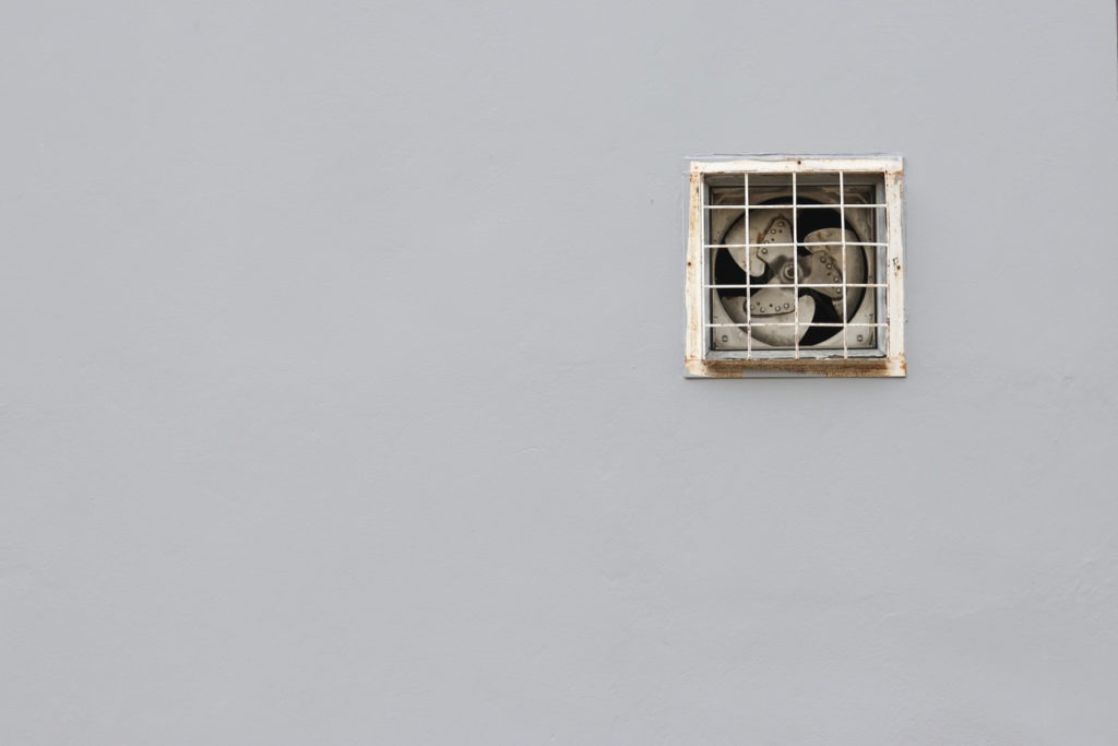 Ventilating fan installed on a gray wall