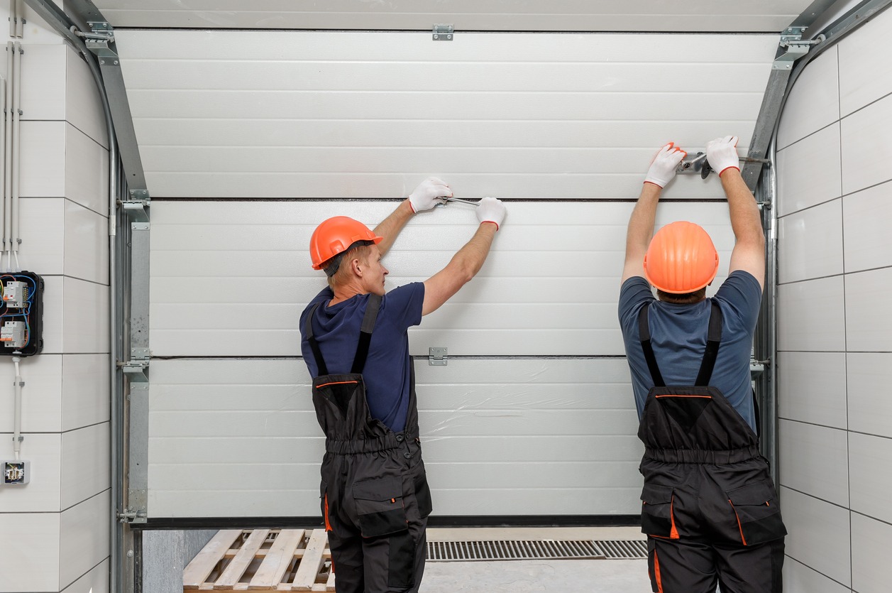 Professional workers are installing lifting gates of the garage
