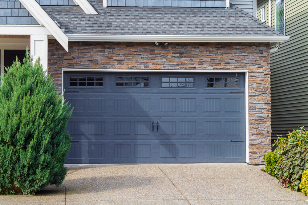House with blue Garage door with windows . Vancouver, Canada. Garage door in luxury house. Street photo, nobody, residential garage. Insulated garage door. Metal door
