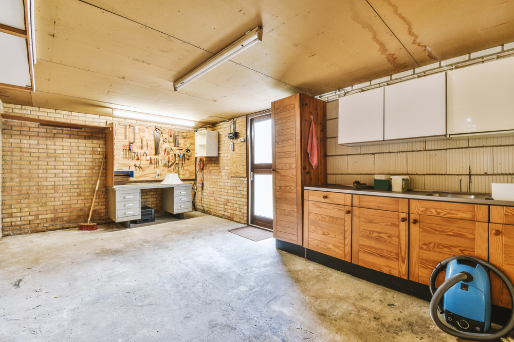 A spacious bright empty garage with brick walls and construction tools in a cozy house