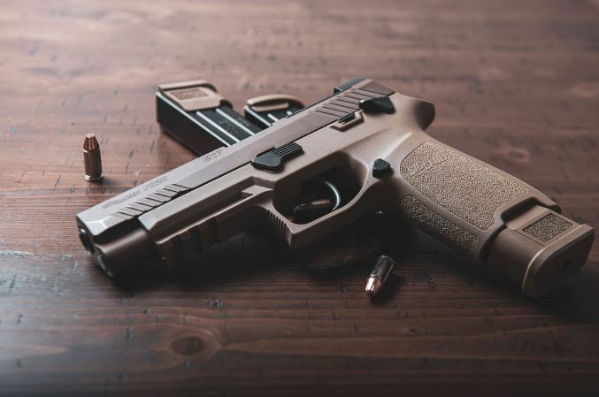 a semi-automatic pistol on a brown wooden table