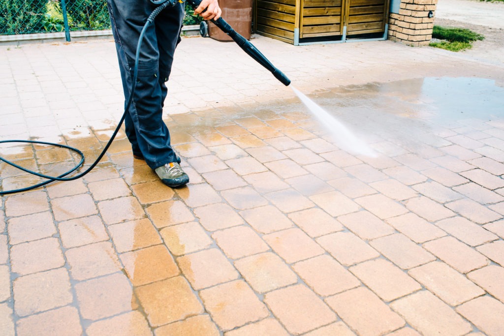 Outdoor floor cleaning with high pressure water jet - cleaning concrete block floor on terrace