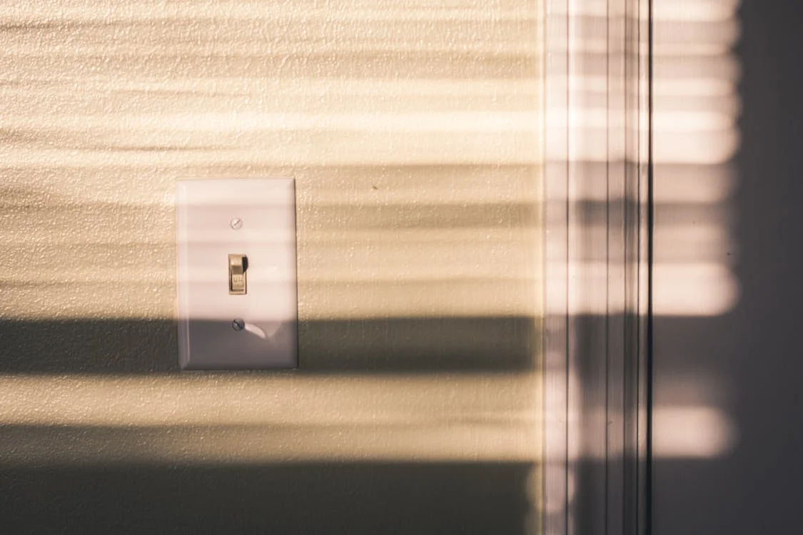 A switch on a wall being illuminated by sunlight